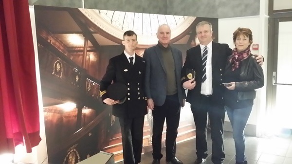 Quatre personnes posent devant la photo du Grand escalier.