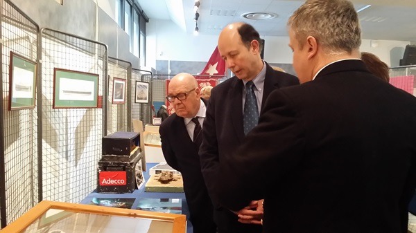 Trois hommes sont penchés sur une vitrine