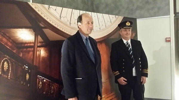 Deux hommes posent devant une photo du Grand escalier.