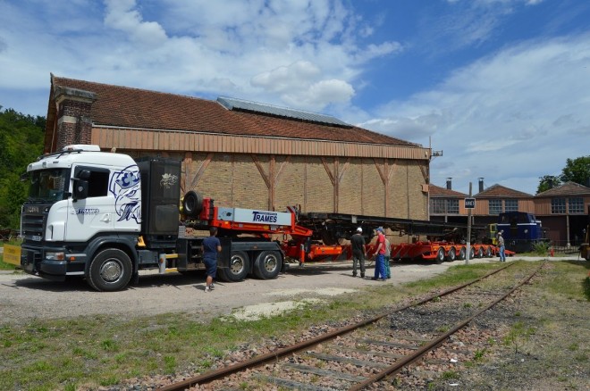 Vue de profil du camion transportant le châssis de la voiture