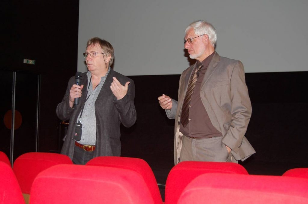 Deux hommes parlent à la salle.