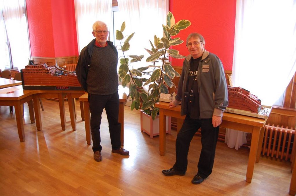 Deux hommes posent devant les maquettes de l'épave