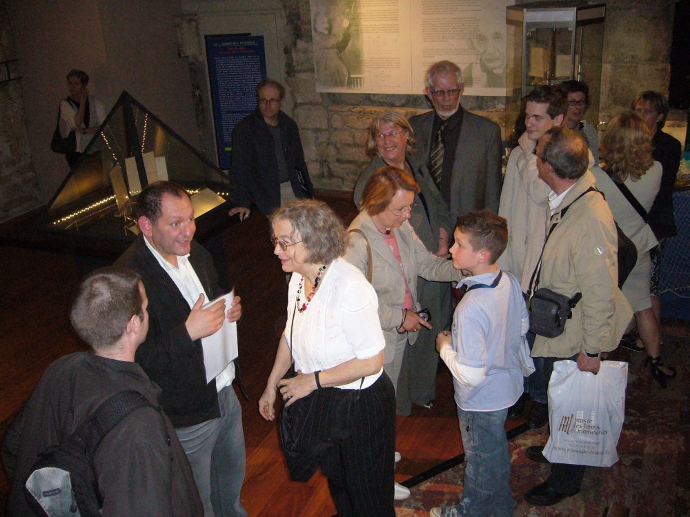 Groupe de personnes discutant à l'entrée.