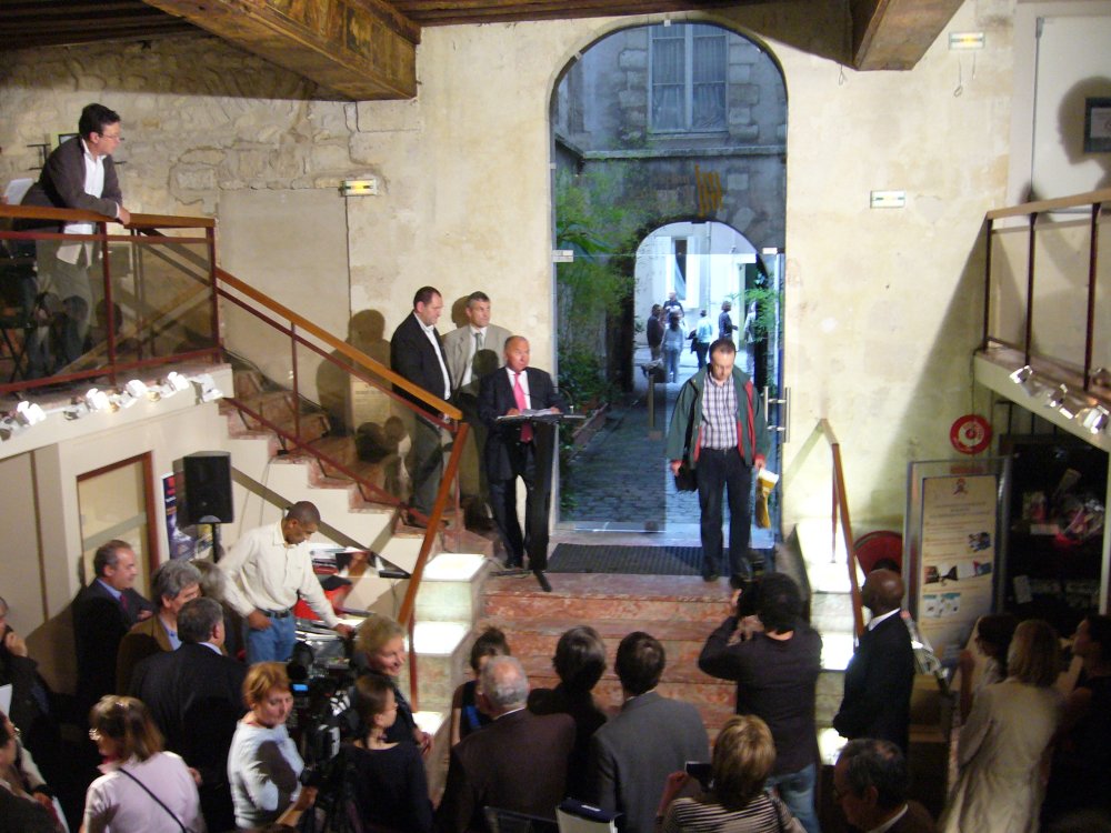 Groupe de personnes discutant à l'entrée.