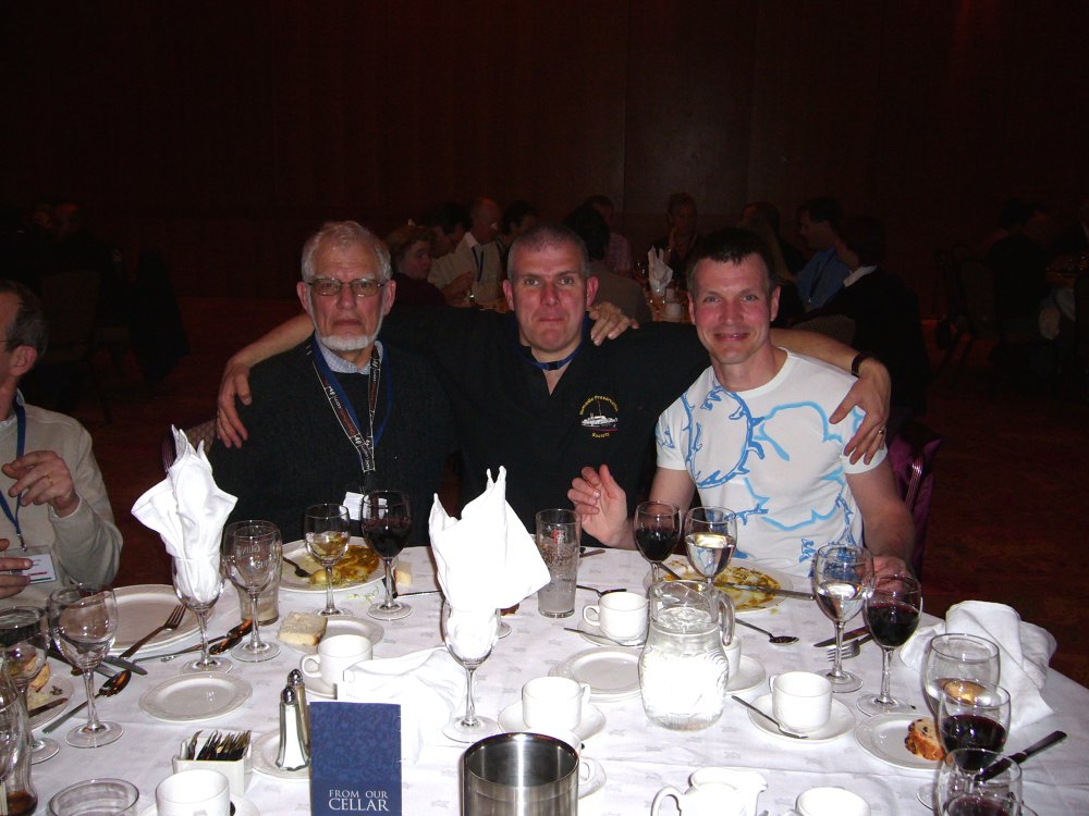 Trois personnes posent à table.
