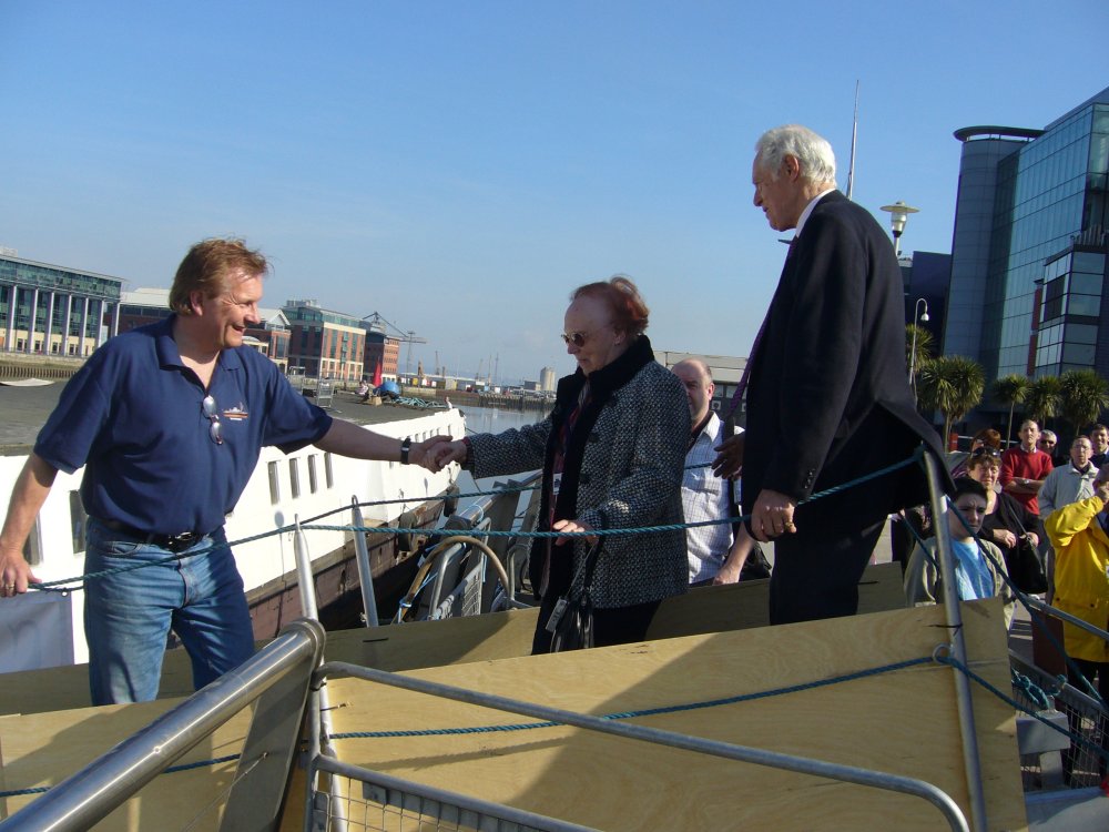 Une dame âgée avance le long de la passerelle d'embarquement.