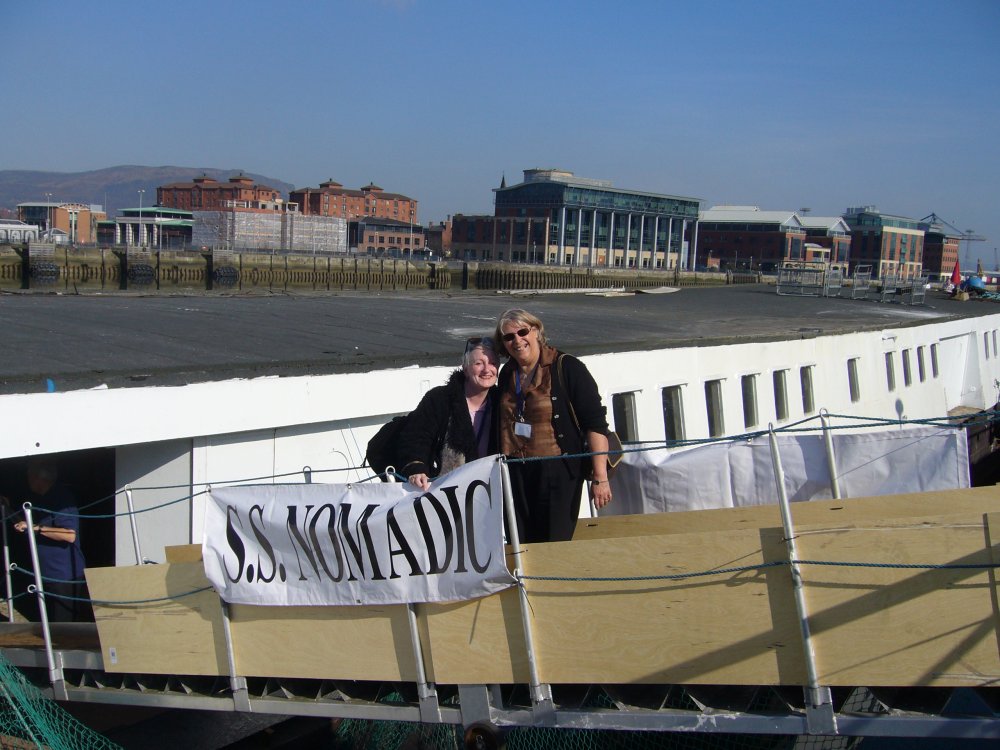 Deux femmes posent sur la passerelle d'embarquement.