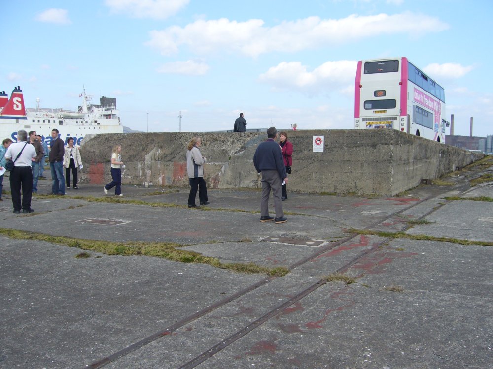 Un groupe se tient devant un terre-plein de béton.