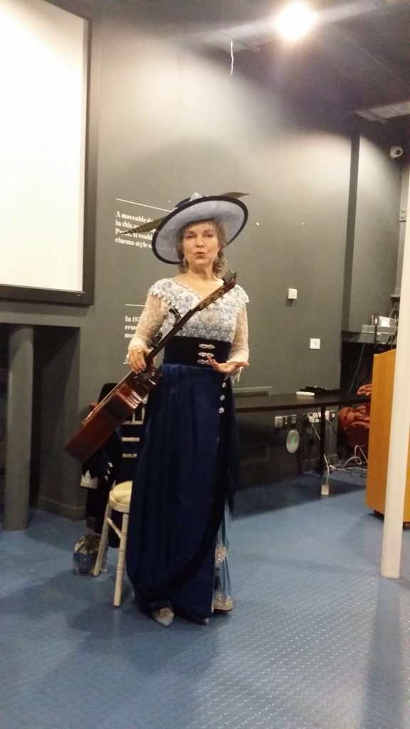 Une femme donne une conférence en tenue d'époque